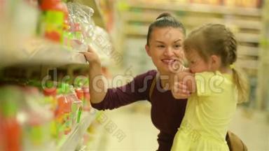 妈妈和女儿正在超市买果汁。 超市购物更有趣。
